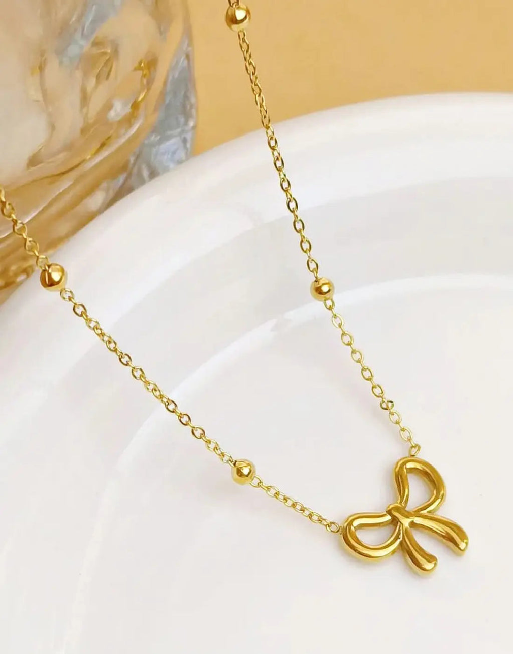 Simple Bowelle necklace by Glitze Accessories featuring a delicate chain and elegant bow pendant.