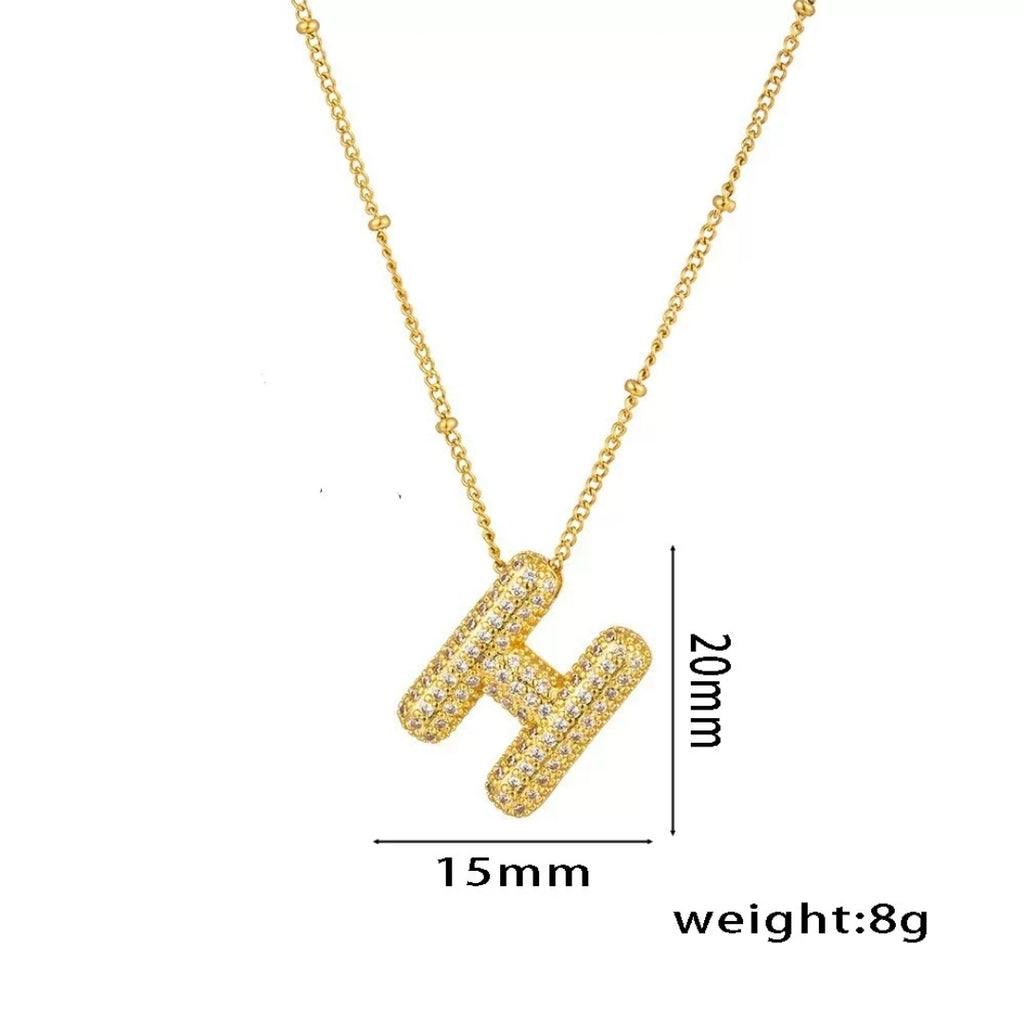 Simple gold initial necklace featuring the letter H from Glitze Accessories, shown on a delicate chain.