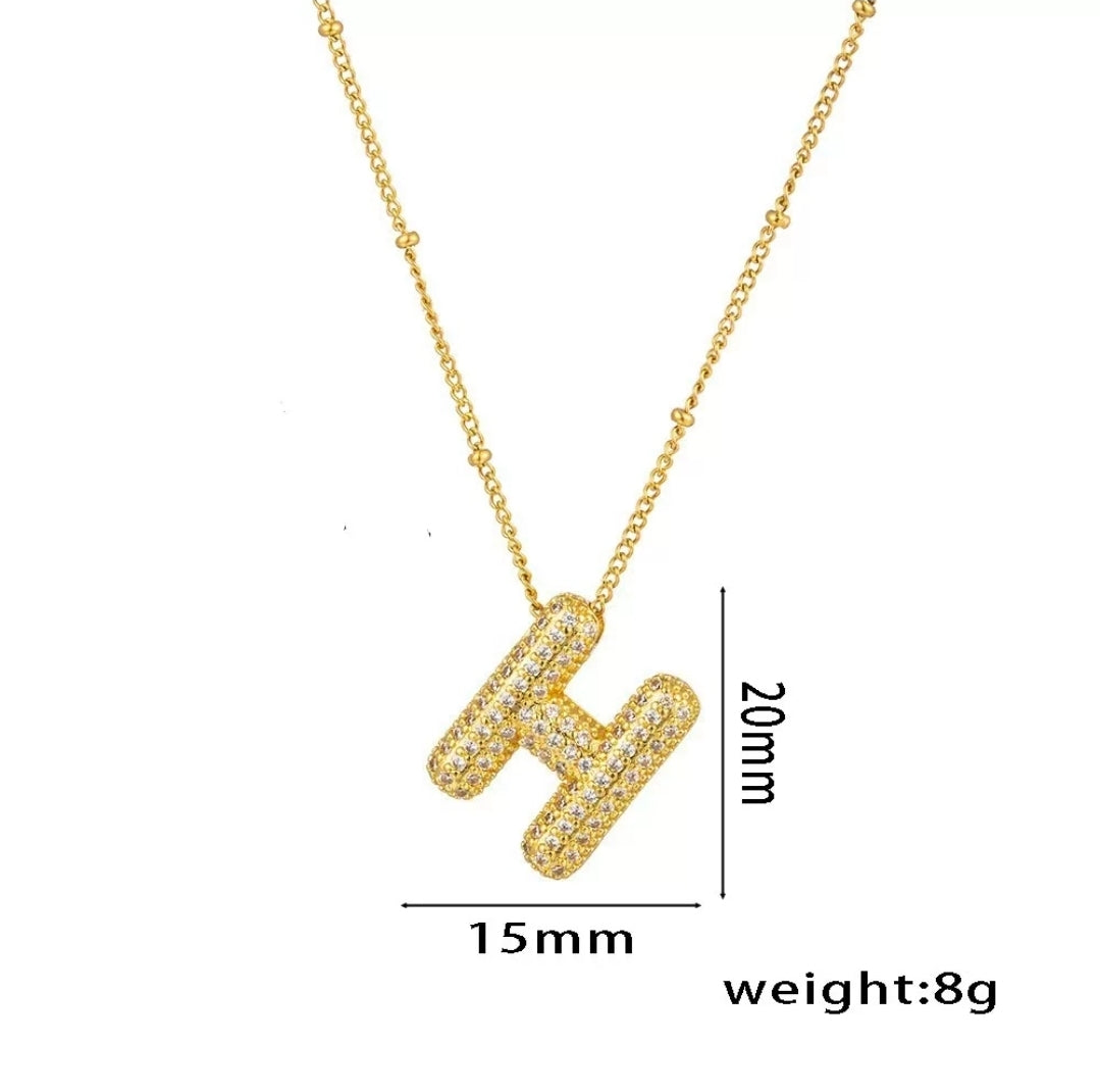 Simple gold initial necklace featuring the letter H from Glitze Accessories, shown on a delicate chain.